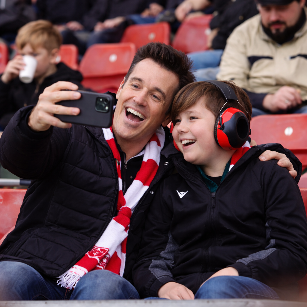 Child and mentor taking a selfie at the stadium